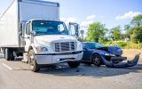 Road accident with damage to vehicles as a result of a collision between a semi truck with box trailer and a car.