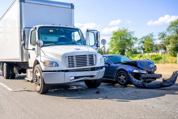 Road accident with damage to vehicles as a result of a collision between a semi truck with box trailer and a car.